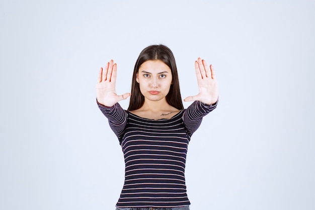 Girl in striped shirt stopping and preventing something. 