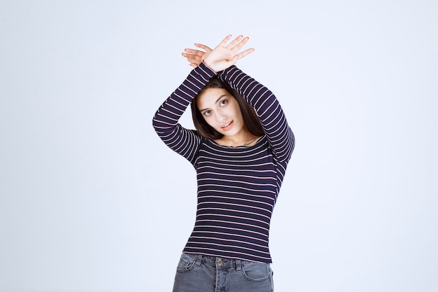 Girl in striped shirt stopping and preventing something. 