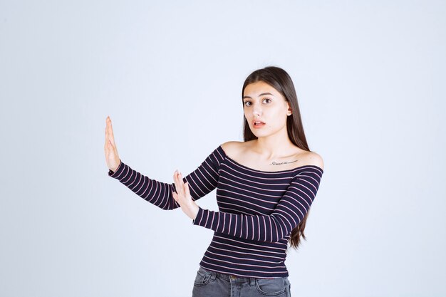 Girl in striped shirt stopping and preventing something. 