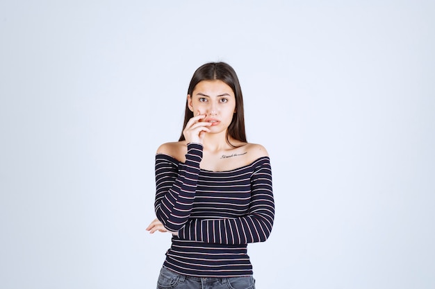 Ragazza in camicia a righe pensando e analizzando.