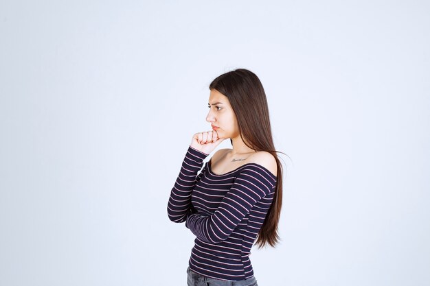 Girl in striped shirt thinking and analizing. 