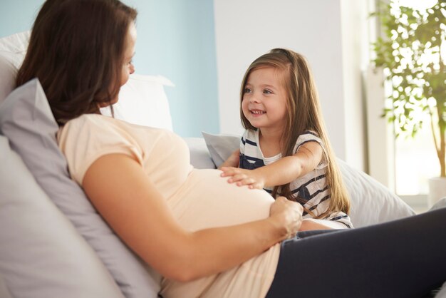 Free photo girl stroking her mum's abdomen