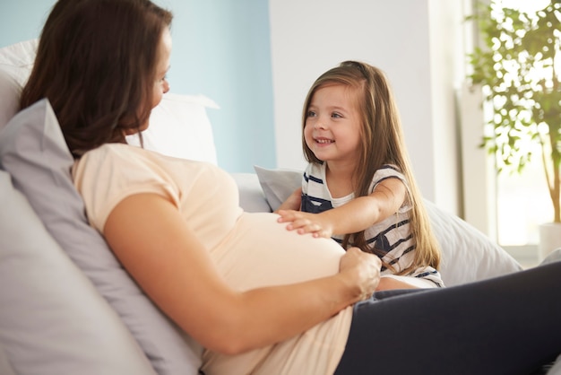 Girl stroking her mum's abdomen