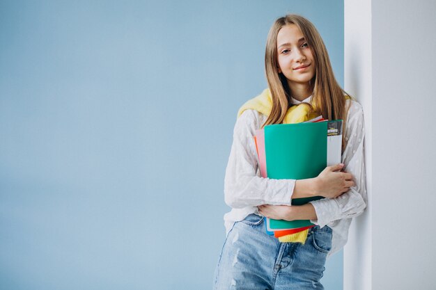 다채로운 폴더와 함께 서있는 여자 학생