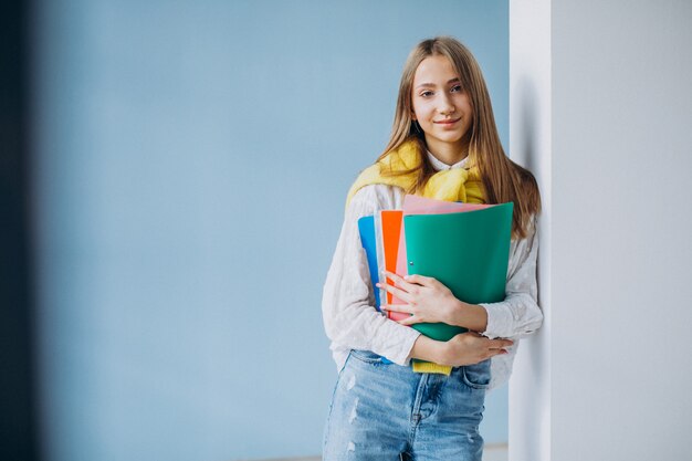 Girl student standing with colorful folders