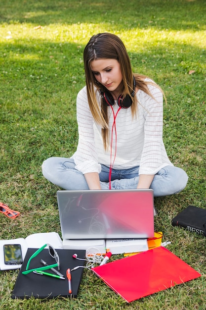 Foto gratuita ragazza che studia sul prato inglese