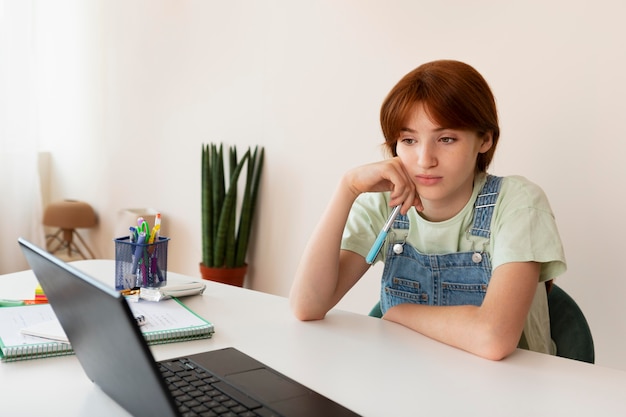 Girl studying with laptop at home medium shot