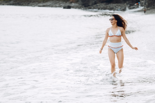 Girl in a stylish swimsuit have a rest n a beach