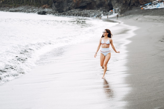 Girl in a stylish swimsuit have a rest n a beach