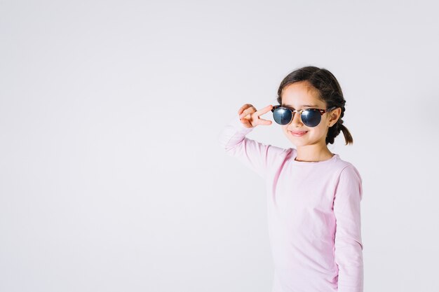 Girl in sunglasses gesturing peace