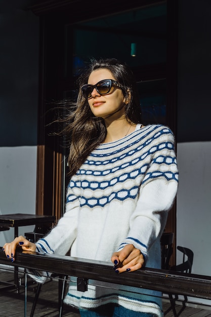 girl in sunglasses in a street cafe