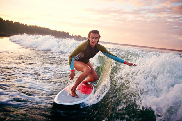 Girl Surfing At Sunset