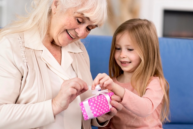 Foto gratuita ragazza sorprendente nonna con regalo