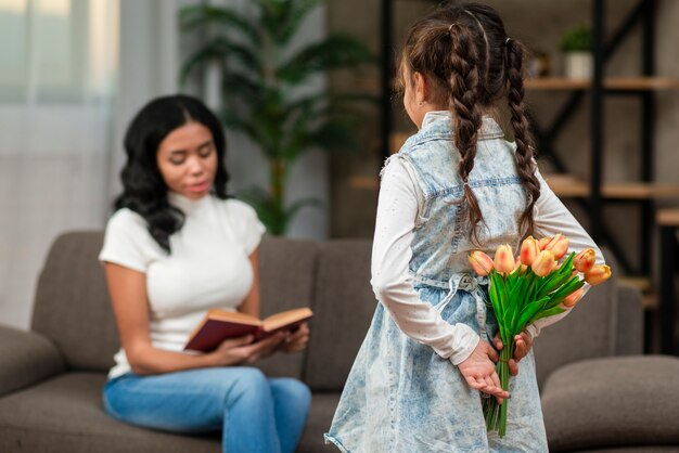 Girl surprising mom with flowers