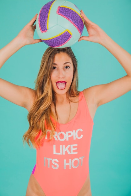 Free photo girl in swimsuit holding volleyball and screaming