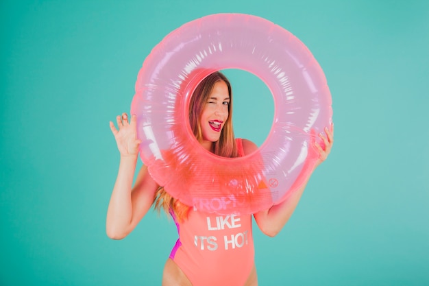 Girl in swimsuit looking through inflatable ring