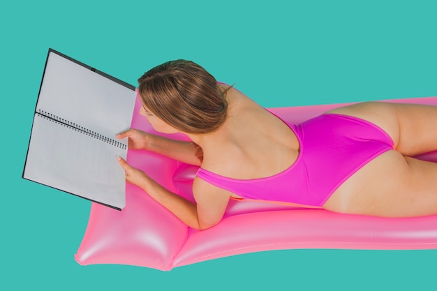 Girl in swimsuit with folder on pool mattress