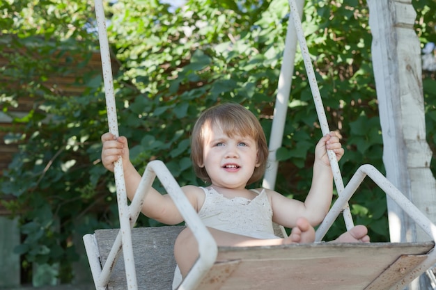 girl on swing in summer park