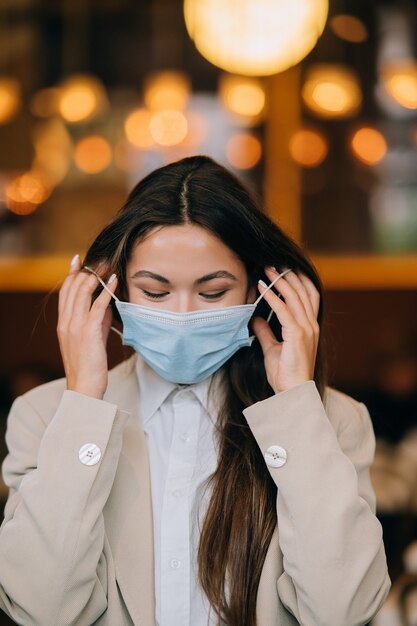 Girl in takes off her protective medical face mask