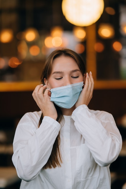 Girl in takes off her protective medical face mask