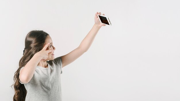 스튜디오에서 모바일에 재미있는 selfie를 복용하는 여자
