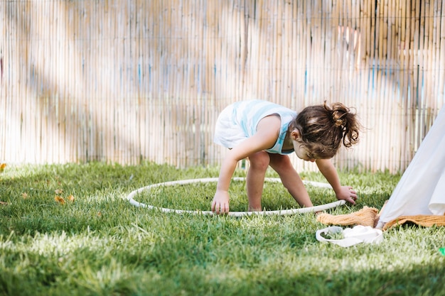 Girl taking hula hoop from ground