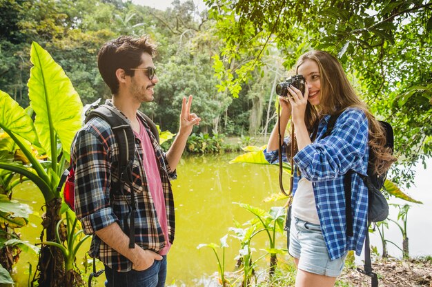 Girl taking photo of boyfriend in the jungle