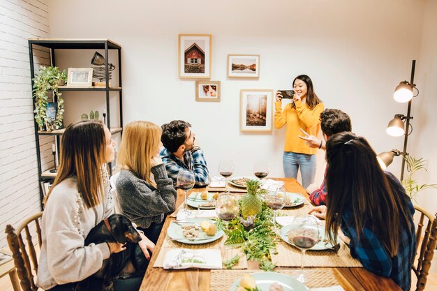 Girl taking photo of friends at table