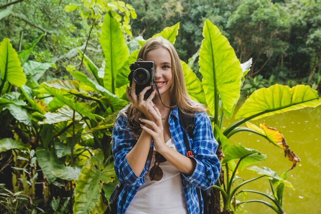 Girl taking photo in jungle front view