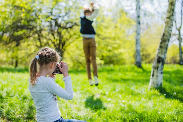 Girl taking photos to her funny brother