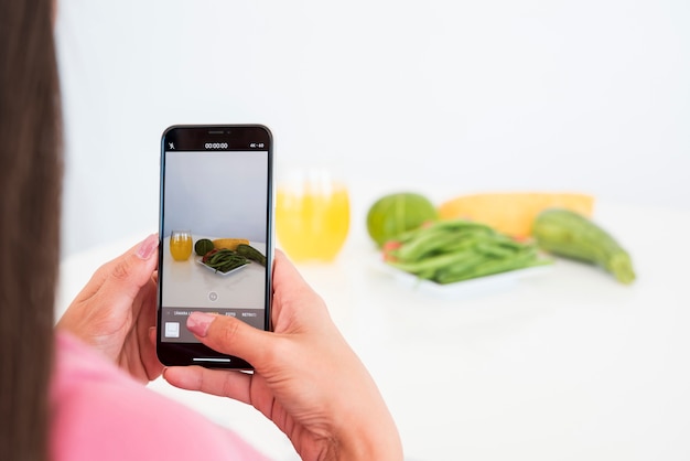 Free photo girl taking picture of vegetable