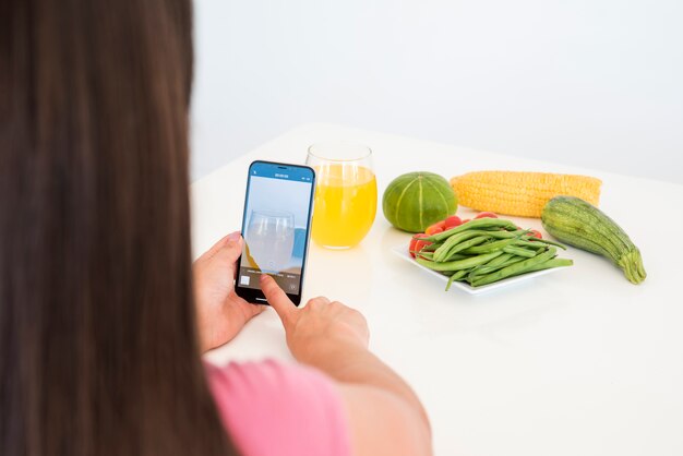 Girl taking picture of vegetable