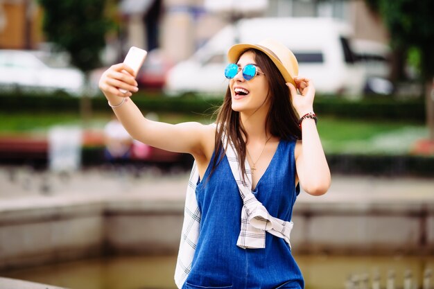 Ragazza che cattura foto selfie vicino alla fontana all'aperto