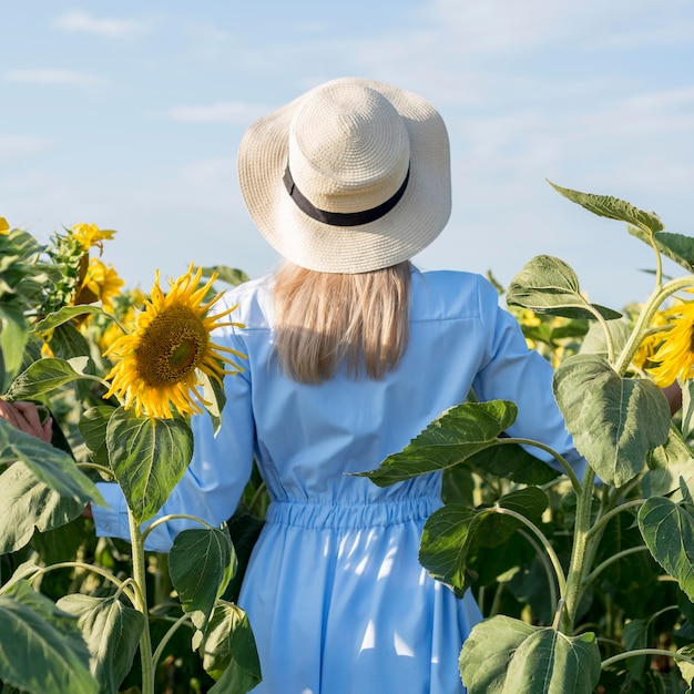 Girl taking a walk in a field with sun flowers