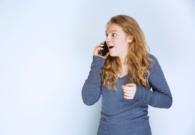 Free photo girl talking to the phone and getting surprized.