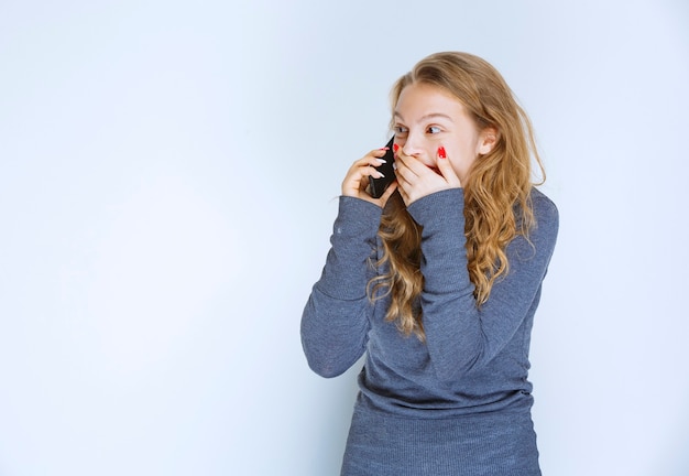 Girl talking to the phone and getting surprized.