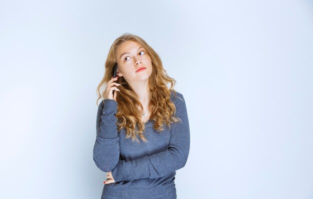 Girl talking to the phone without any reaction.