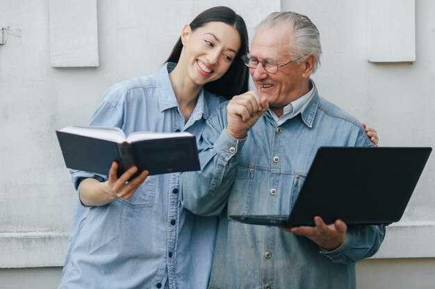 Girl teaching her grandfather how to use a laptop