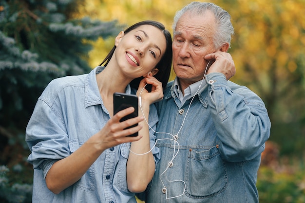 Girl teaching her grandfather how to use a phone