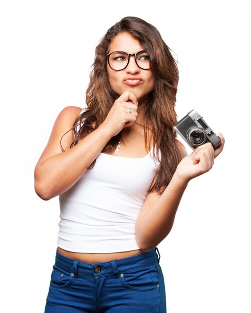 Girl thinking with camera in hand