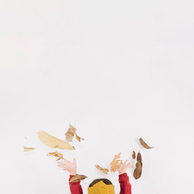 Girl throwing autumn leaves