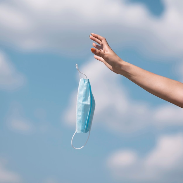 Girl throwing out a medical mask