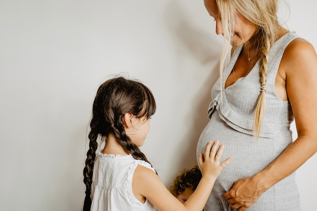 Girl touching belly of pregnant mother