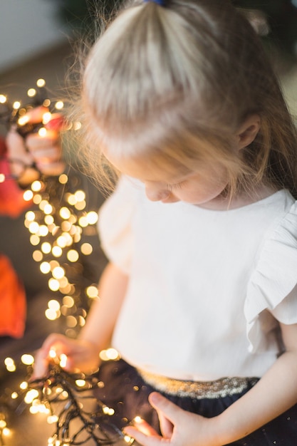 Girl touching christmas lights