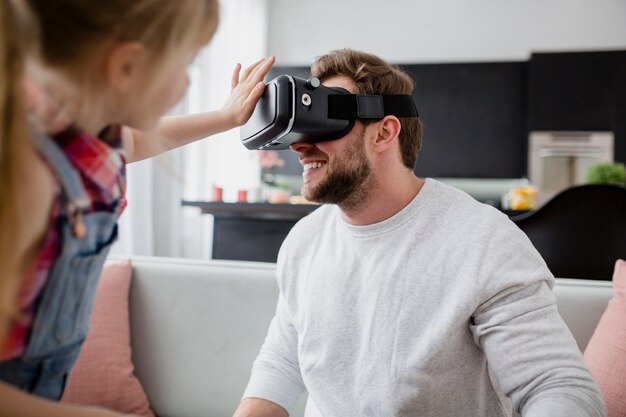 Girl touching VR glasses on father