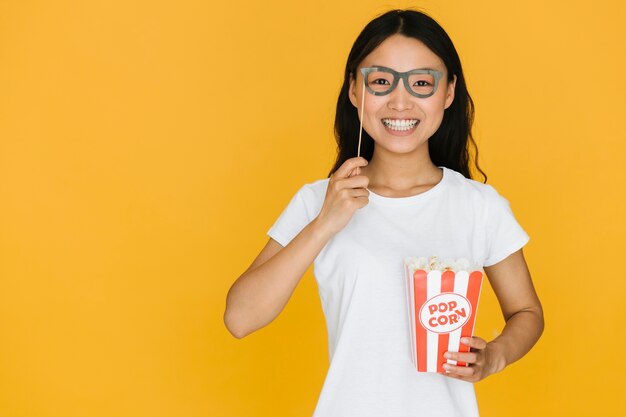 Girl trying on fake glasses with copy space