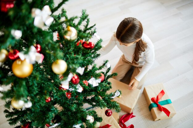 Girl unpacking xmas gift, top view