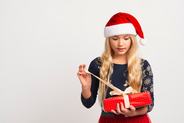 Girl unwrapping present studio shot