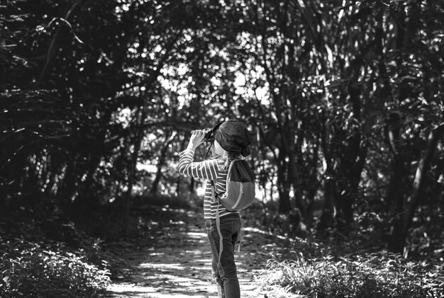 Girl using binoculars in the forest