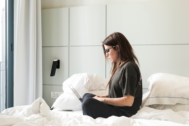 Girl using laptop on bed